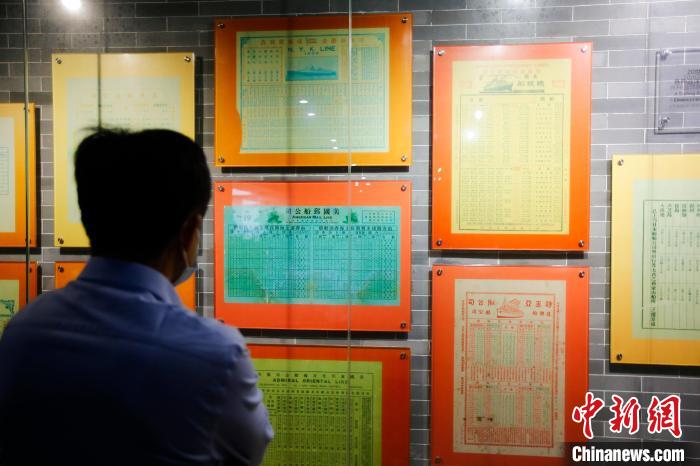参观者正在阅览博物馆陈列的离乡移民时所乘游轮船期表。 王骏 摄
